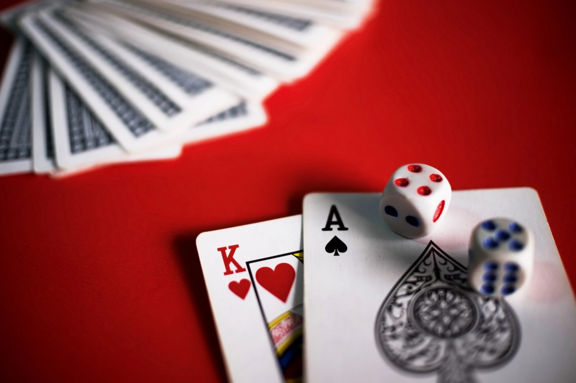 Blackjack-kort og terninger på et rødt spillebord