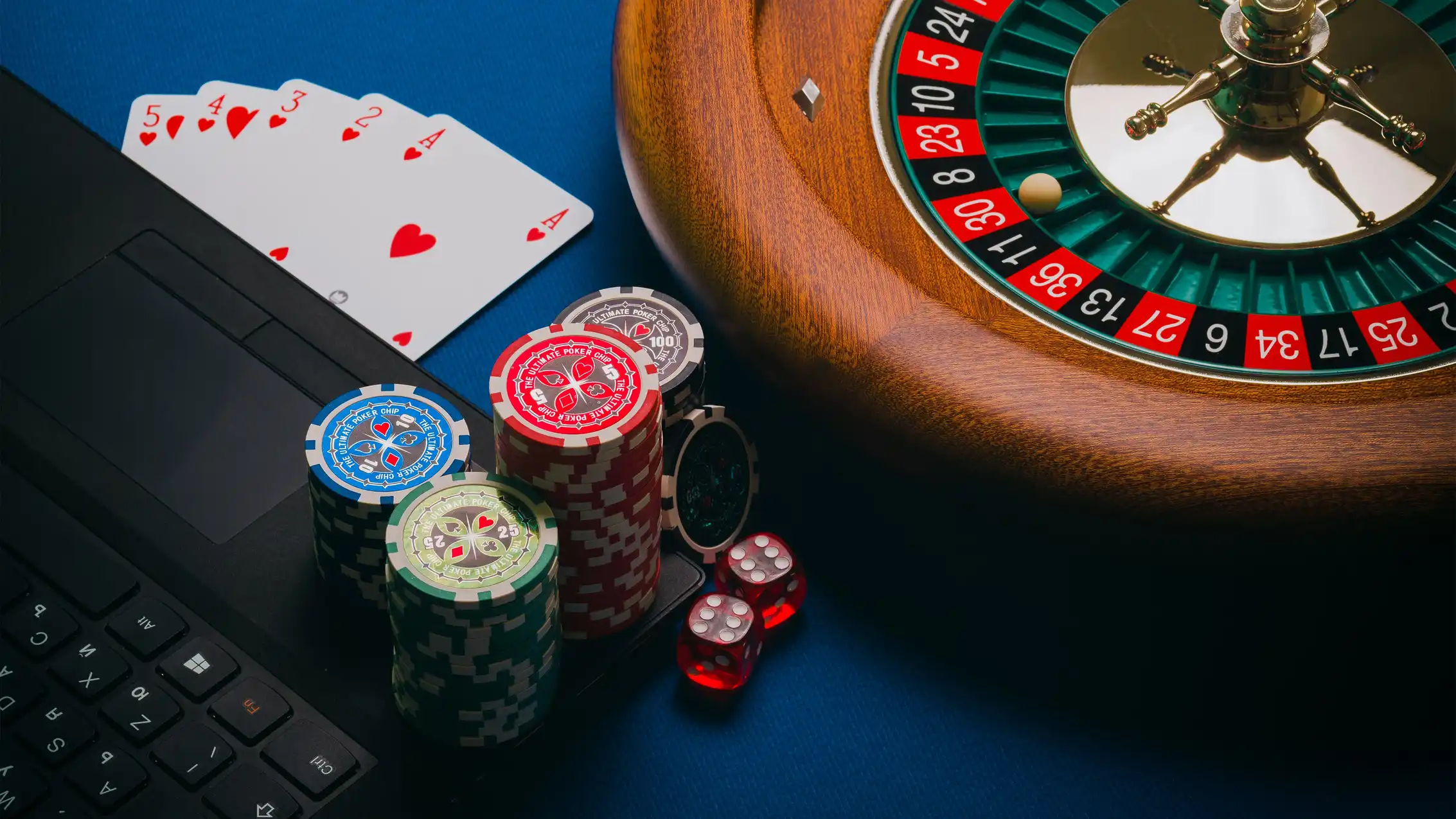 Nettspill med rulett, kort og casinochips ved en bærbar PC